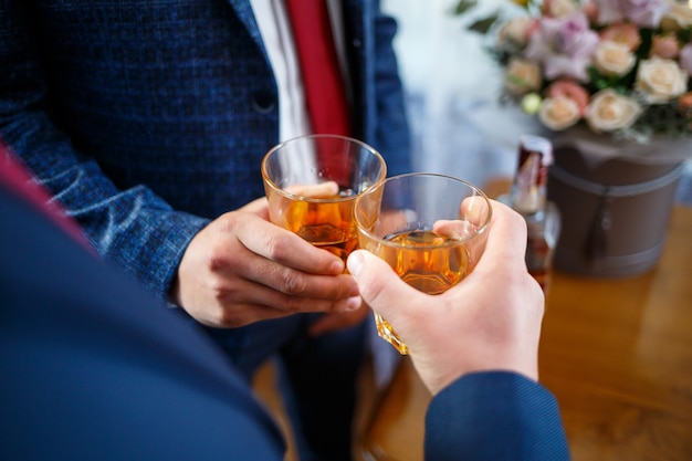 Un homme en costume avec un verre à la main