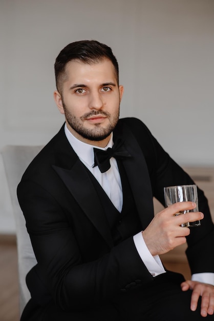 homme en costume avec un verre de whisky à la main