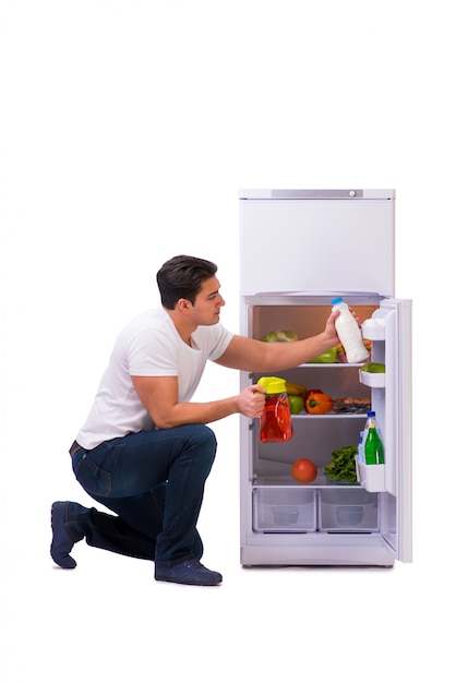 Homme à côté du frigo rempli de nourriture