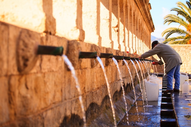 Homme à côté de la fontaine