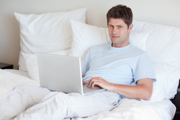 Homme couché dans son lit avec un cahier