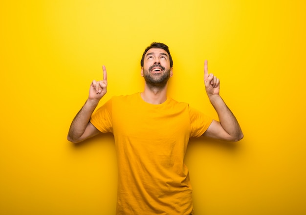 Homme sur une couleur jaune vibrante isolée pointant avec l&#39;index une excellente idée