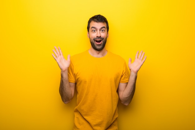 Homme de couleur jaune vibrante isolée avec surprise et expression faciale choquée