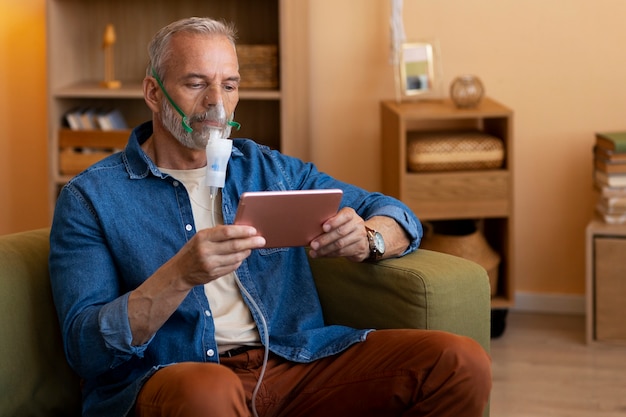 Photo homme de coup moyen utilisant un nébuliseur