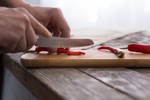 Homme coupant du piment fort