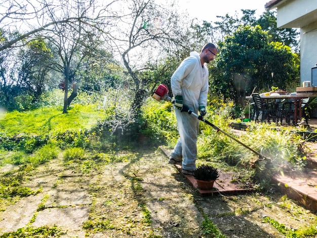 Homme coupant de l'herbe l'herbe dans le jardin