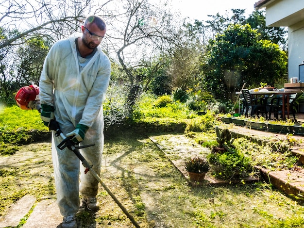 Homme coupant de l'herbe l'herbe dans le jardin