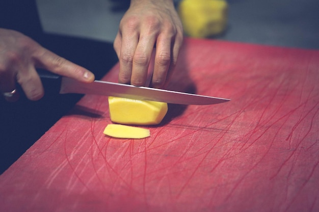 L'homme coupe les pommes de terre pour la cuisson