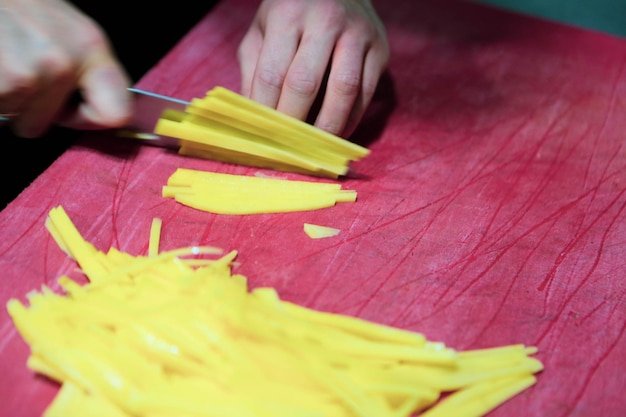 L'homme coupe les pommes de terre pour la cuisson