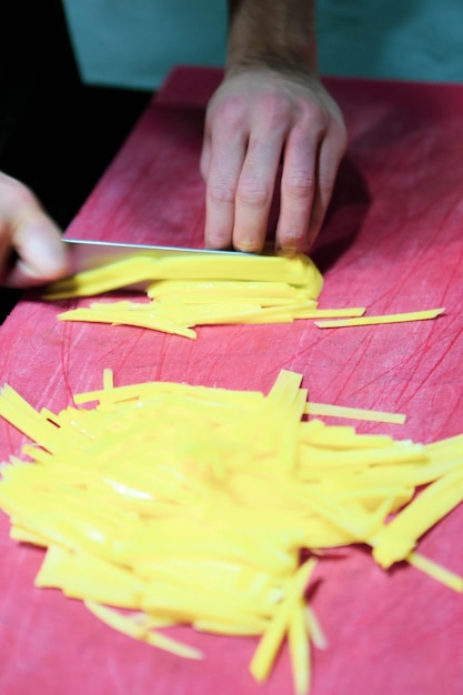 L'homme coupe les pommes de terre pour la cuisson