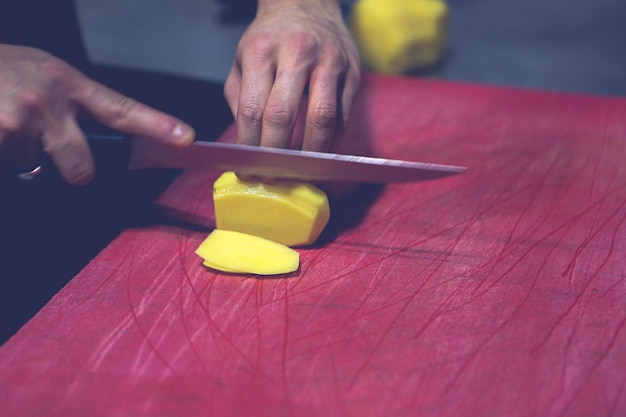 L'homme coupe les pommes de terre pour la cuisson