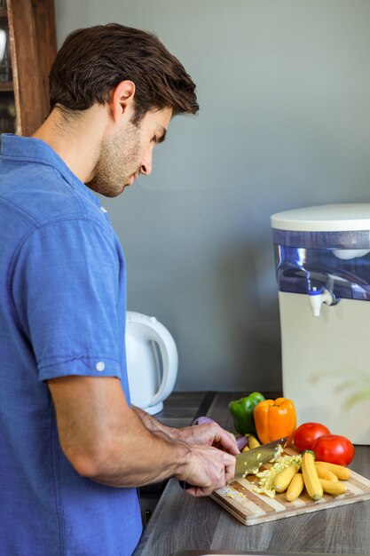 Homme, couper les légumes au comptoir de la cuisine