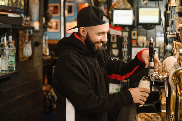 Un homme courageux barbu vous verse une boisson moussante