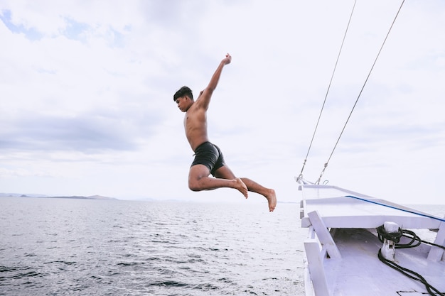 Homme courageux sautant dans la mer depuis un bateau