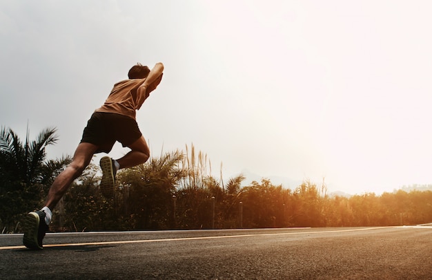 Homme coureur commence à courir sur la route