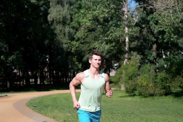 Homme courir dans le parc le jour d'été ensoleillé