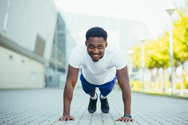 Homme en course matinale, jeune athlète afro-américain faisant du fitness près du stade