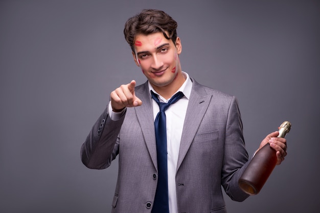 Homme couvert de bisous avec une bouteille de champagne