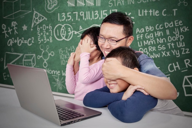 Homme couvrant les yeux de ses enfants à partir du contenu en classe