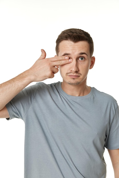 Un homme couvrant les yeux avec ses mains sur un fond blanc