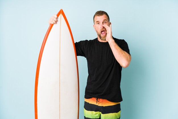 Homme criant et tenant la planche de surf