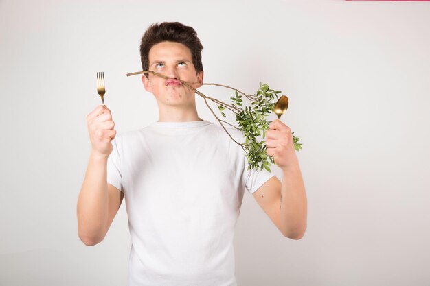 Homme avec cuillère et fourchette sur blanc