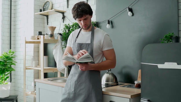 Homme cuisine dans la cuisine lecture recette du livre de cuisine