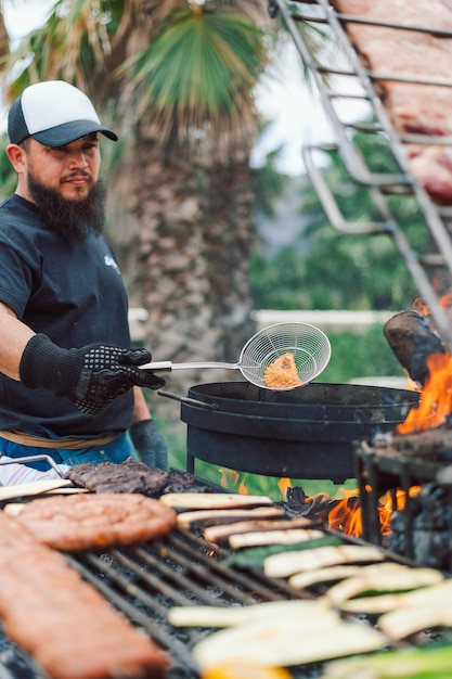 Photo a, homme, cuisine, nourriture, sur, a, gril, à, a, chapeau