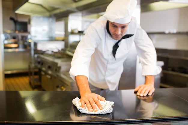 Homme cuisinier essuyant le comptoir de la cuisine