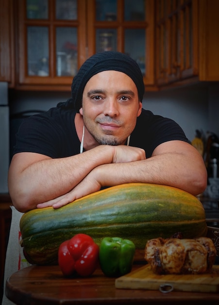 Homme cuisinier avec des légumes souriant à la maison