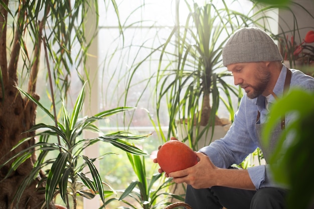 Homme cultivant des légumes dans son jardin intérieur