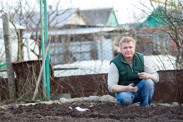 L'homme cultive les graines de radis, dans le jardin