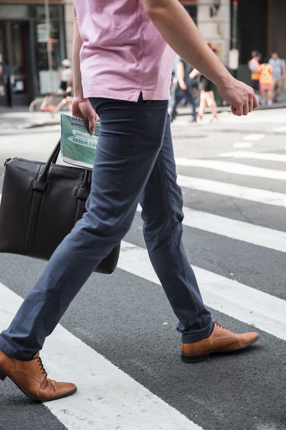 Photo homme de culture avec sac traversant la route