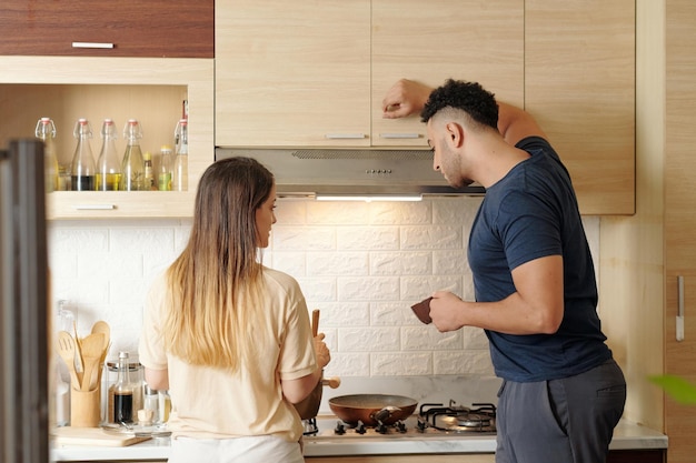 homme curieux, regarder cuisine, femme