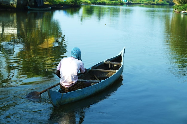 Un homme dans un bateau rame un bateau.