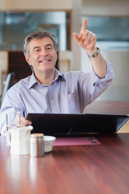 Homme dans un café appelant le serveur