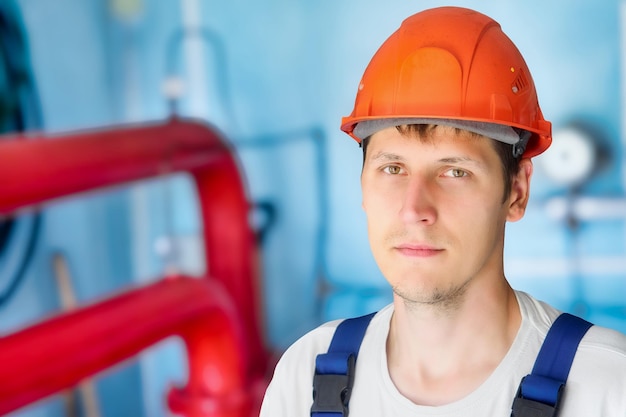 L'homme dans le casque de construction regarde directement dans la cellule à l'intérieur de la pièce Portrait authentique d'un vrai travailleur du gaz