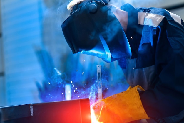 Homme dans un casque de protection travaillant avec une construction en métal lourd Ingénierie professionnelle en uniforme