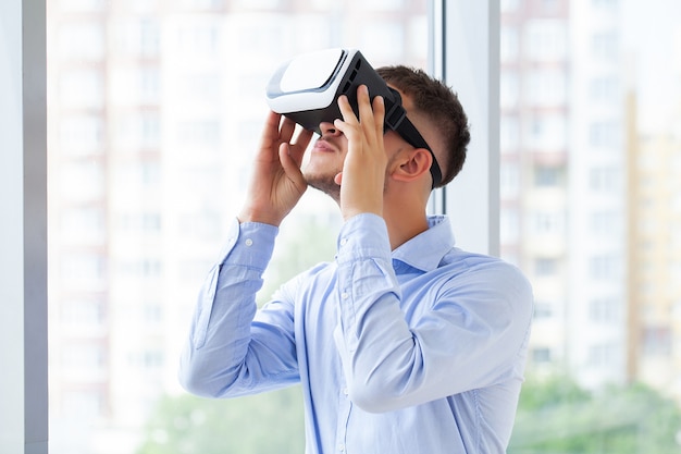 Homme dans un casque VR essayant de toucher des objets en réalité virtuelle