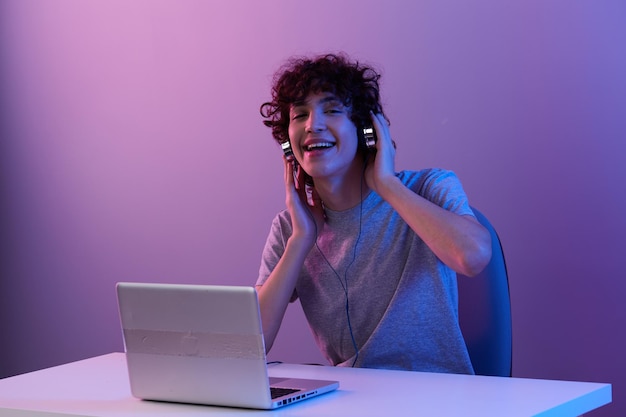 Homme dans les écouteurs devant le fond isolé de divertissement pour ordinateur portable