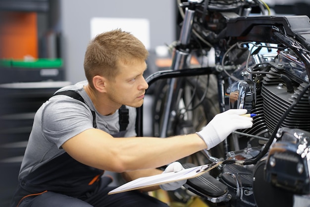 Photo un homme dans le garage vérifie une moto