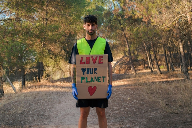 Homme dans un gilet réfléchissant avec un signe protestant contre la pollution mondiale