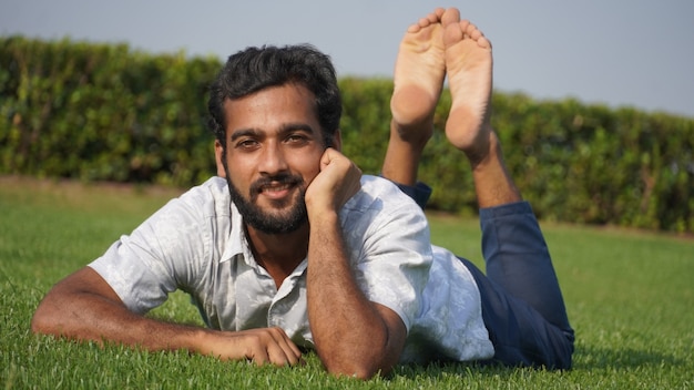 Homme dans l'herbe et souriant