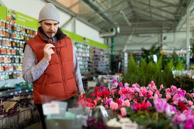 Un homme dans un magasin de fleurs choisit un bouquet pour son amant