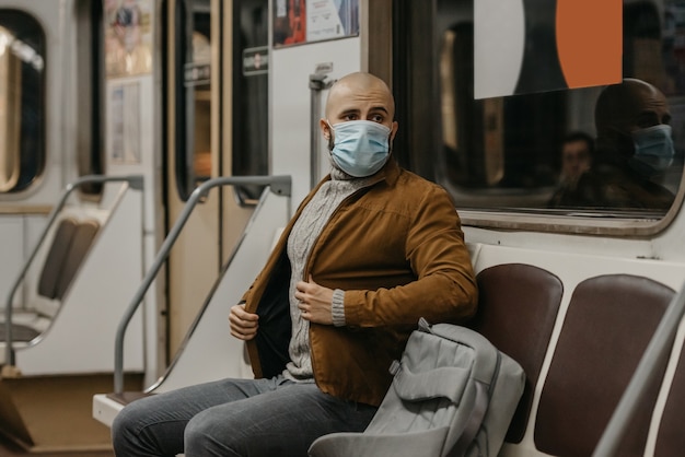 Un homme dans un masque médical à la station de métro