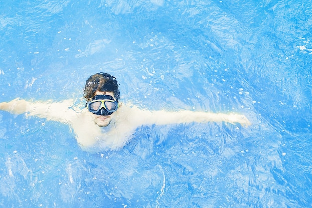 L'homme dans un masque sous-marin émerge de l'eau plongeant dans l'océan en vacances le gars avec son ar...