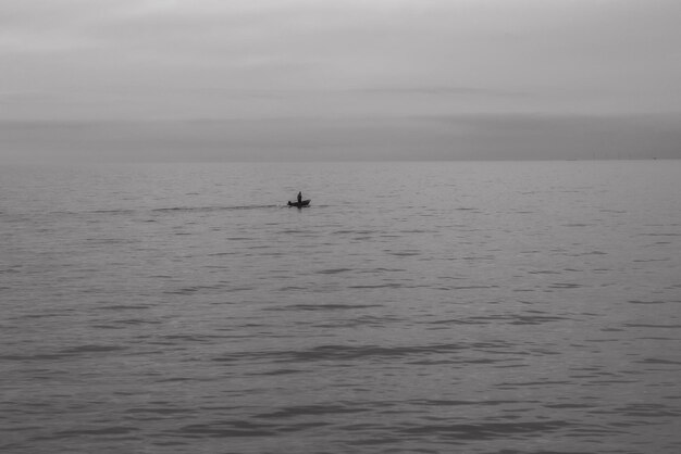 Photo l'homme dans la mer contre le ciel