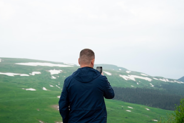 Photo un homme dans les montagnes avec un téléphone