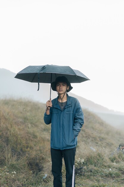 Un homme dans les montagnes tenant un parapluie