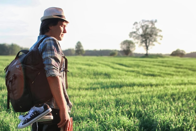 Homme dans la nature avec sac à dos et livre de lecture